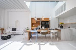 a kitchen and living room with a table and chairs at Pnoe in Mýkonos City