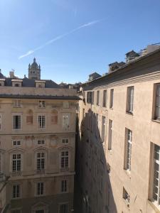 ein Gebäude mit einem Uhrturm in der Ferne in der Unterkunft Le coccole in Genua