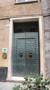 ein Fenster in einem Gebäude mit grüner Tür in der Unterkunft Le coccole in Genua
