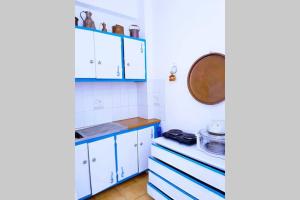 a small kitchen with blue cabinets and a stove at Yacht Front Studio - No 4 in Ios Chora