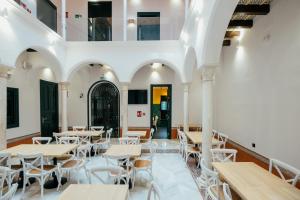 una habitación con mesas y sillas en un restaurante en Hotel Cetina Sevilla en Sevilla