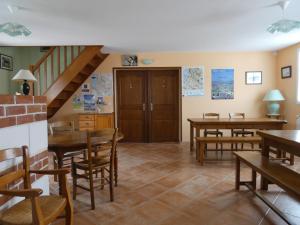 a dining room with tables and chairs and a staircase at Les Chambres d'Ebalet in Saint-Blimont