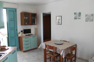 Il comprend une cuisine avec une table, des chaises et un bureau. dans l'établissement ARIES CASE VACANZA - Tsg, à Torre San Giovanni 5 autres photos