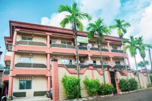 a building with palm trees in front of it at Résidence Hotelière Borel Denver in Douala