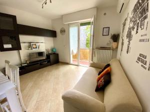 a living room with a couch and a television at Casa Lavanda in Torri del Benaco