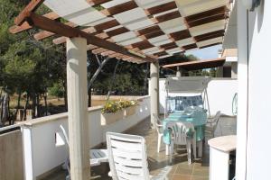 un patio avec une table et des chaises sous une pergola dans l'établissement ARIES CASE VACANZA - Tsg, à Torre San Giovanni