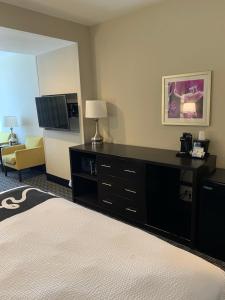 a hotel room with a bed and a dresser with a television at La Quinta by Wyndham Hattiesburg - I-59 in Hattiesburg