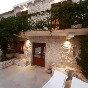 Casa de piedra con puerta de madera y balcón en Villa Dragi en Klek