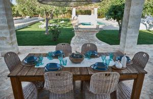 una mesa de madera con cuencos y platos en ella en Villa Amore Bianco, en Ostuni