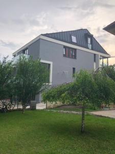 a large white house with a tree in front of it at Apartmanhotel Baraton*** in Balatonfüred