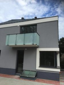 uma casa branca com uma varanda e duas janelas em Apartmanhotel Baraton*** em Balatonfüred