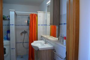 łazienka z pomarańczową zasłoną prysznicową i umywalką w obiekcie Villa Rosy w mieście Nardò