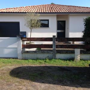 una valla de madera frente a una casa en VILLA 800 MÈTRES DE LA PLAGE, en Andernos-les-Bains