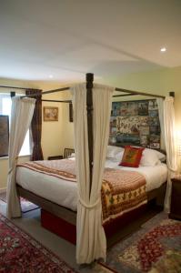 a bedroom with two beds with curtains on them at The Old Deer House in Bodmin