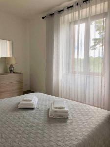 a bedroom with a bed with two towels on it at La Casa del Villanu in Pitigliano