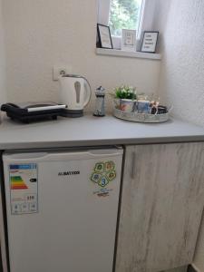 um frigorífico branco debaixo de um balcão numa cozinha em ENKI em Eforie Nord