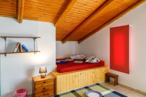 een kamer met een bed met een rode matras bij Ρήγας: Όμορφα στο Μεσολόγγι. Δ2 in Mesolongion