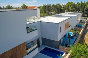 an aerial view of a white building with a swimming pool at Novalja Bay Villas in Novalja