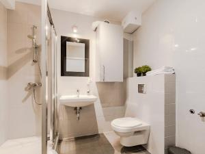 a white bathroom with a toilet and a sink at VacationClub - Myśliwska 60 Apartament 1 in Karpacz