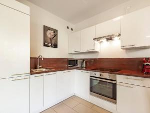 a white kitchen with white cabinets and a sink at VacationClub - Myśliwska 60 Apartament 1 in Karpacz