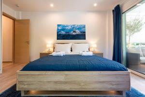 a bedroom with a large bed with blue sheets at Lux 1-bedroom apartement next to the sea in Voula in Athens