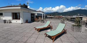 two lounge chairs sitting on a patio on a roof at La Suite attico metro' Volta in Brescia