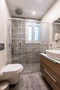 ein Bad mit einer Dusche, einem WC und einem Waschbecken in der Unterkunft Lux 1-bedroom apartement next to the sea in Voula in Athen
