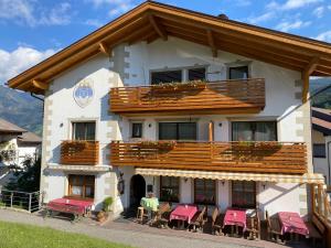 ein Gebäude mit einem Balkon mit Tischen und Stühlen in der Unterkunft Gasthaus St. Valentin in Klausen