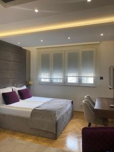 1 dormitorio con 1 cama grande y escritorio en Aria Royal apartment en Belgrado