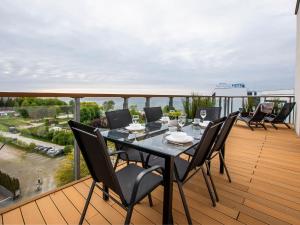 einen Esstisch und Stühle auf einem Balkon mit Aussicht in der Unterkunft VacationClub - Olympic Park Apartament A605 in Kołobrzeg