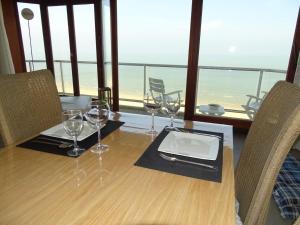 a table with wine glasses and a tablet on it at LUXURY APP, frontal sea View + south terrace + garage in Middelkerke