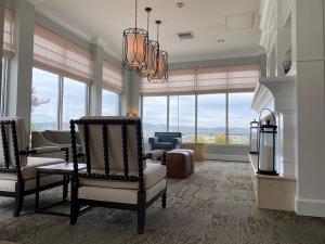 a living room with a couch and chairs and windows at Shutters Hotel in Elko