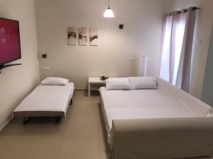 a hospital room with two beds and a tv at Green View Apartment in Áyios Pétros