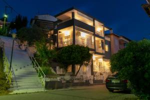 a large building with stairs leading up to it at night at Family Inn Apartments&suites in Neos Marmaras