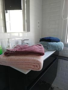 y baño con lavabo y toallas rosas y azules. en Le charme de l ancien entre mer et ville, en Le Havre