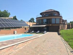 ein Gebäude mit einem Pool und einem Gebäude mit Sonnenkollektoren in der Unterkunft Royal Villa Keszthely in Keszthely