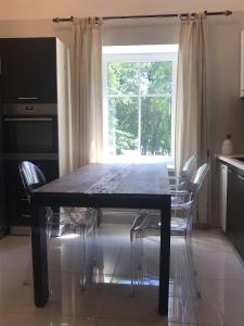uma mesa de jantar com cadeiras e uma janela em Villa Kertelhof Guesthouse em Kärdla