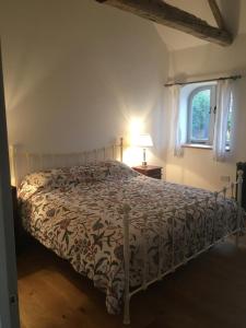 ein Schlafzimmer mit einem Bett mit einer Bettdecke und einem Fenster in der Unterkunft Hookcar Hill Cottage in Bedale