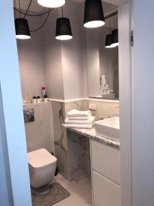 a bathroom with a toilet and a sink and a mirror at Apartament Bellamore in Gdańsk