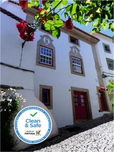 a white house with a sign in front of it at Casa da Rua Nova in Castelo de Vide