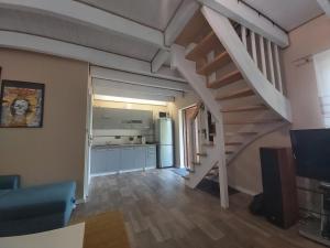 a living room with a staircase and a kitchen at Letnia Ostoja Wieprz in Wieprz