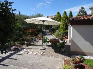 a patio with an umbrella and a table and chairs at Apartma Na Trati in Izola