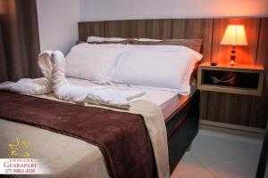 a bedroom with a bed with a towel on it at MAIOR NOTA - 90 metros da Beira Mar - 2 Quartos com AR CONDICIONADOS SPLIT, Air Fryer, Wi-Fi, Disney Plus, Star Plus, HBO Max, Cadeiras de Praia, Caixa Térmica, Churrasqueira, Rede para Descanso e Chuveirão - 8 pessoas - Melhor Localização! in Guarapari