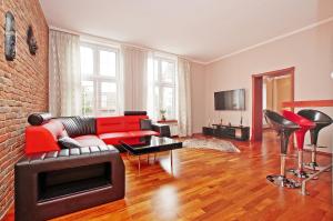 a living room with a red couch and chairs at BaySide Apartments MainCity in Gdańsk