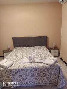 Un dormitorio con una cama con dos zapatos blancos. en Panorama Lucano, en Altamura