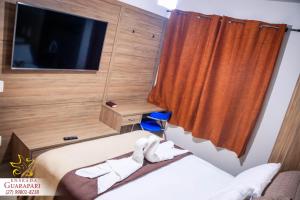 En eller flere senger på et rom på CONFORTO IMBATIVEL - 25 metros do MAR - 2 Quartos com AR CONDICIONADOS SPLIT, Air Fryer, WI-FI, Netflix, Disney Plus, Star Plus, HBO Max, Guarda Sol, Cadeiras de Praia - 8 pessoas com muito conforto!