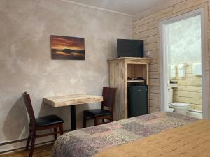 比克的住宿－Motel du Bic，卧室配有一张床和一张桌子及椅子