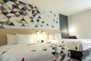 ein Hotelzimmer mit 2 Betten und einem Wandbild in der Unterkunft La Quinta Inn & Suites by Wyndham Lake City in Lake City