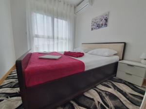 AS Apartments Rafailovici في رفايلوفيتشي: غرفة نوم مع سرير مع لاب توب عليه