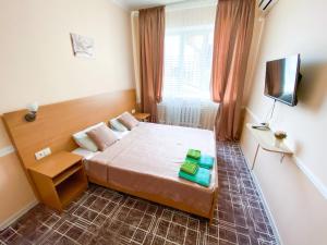 mały pokój z łóżkiem i telewizorem w obiekcie Гостевой дом "Маячок" w mieście Gelendżyk